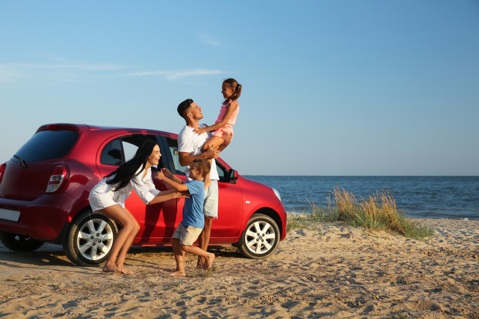 Family with their car at the beach